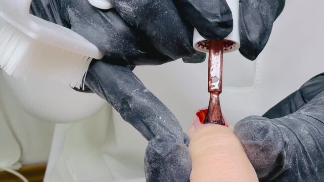 Pedicure close‑up &mdash; applying brown gel polish on big toenail, professional nail care