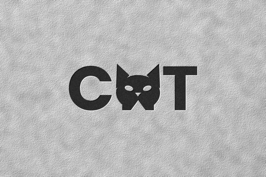 Minimalist typography logo design of the word CAT. Features bold black text with a stylized cartoon cat head icon substituting the letter A, isolated on a light gray texture background.