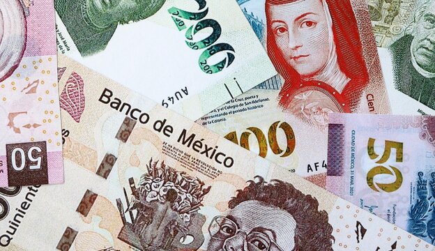 Mexican peso money bills in pile on table. Mexico MXN currency cash close up