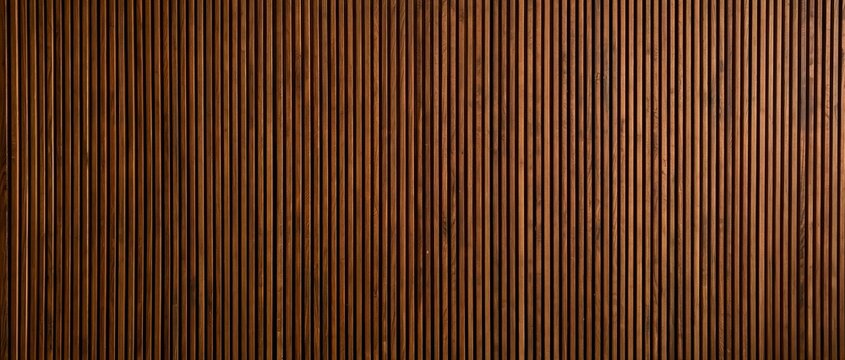 Rich brown wooden wall panel with vertical acoustic grooves showcasing natural grain and texture under soft warm lighting for interior design and architectural applications