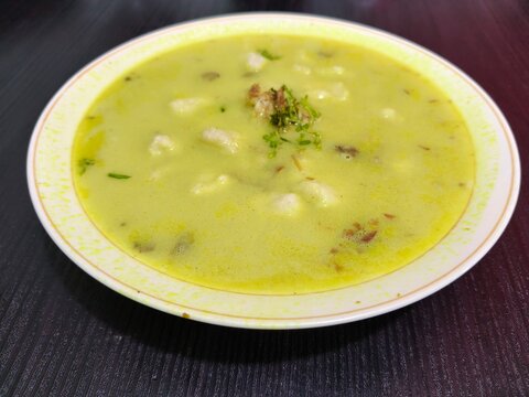 Bowl of Green Soup on Dark Table