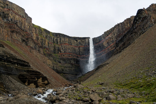 Hengifoss waterfall in a cliff with red clay layers