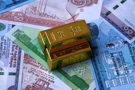 Ethiopian birr money bills and gold bullion bars. Ethiopia cash bills of ETB currency close up