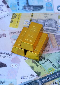 Yemeni rial money bills and gold bullion bars. Yemen cash bills of YER currency close up