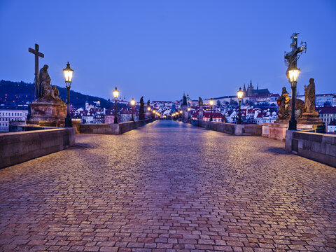 Crucifix and Pieta statues on Charles Bridge at blue hour