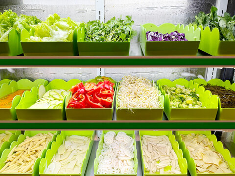 Assorted Wok Ingredients on Display in Asian Restaurant &ndash; Fresh Mushrooms, Greens, Sliced Vegetables, Various Noodles, Glass Noodles, Meatballs, Shrimp and Chicken for Custom Stir-Fry