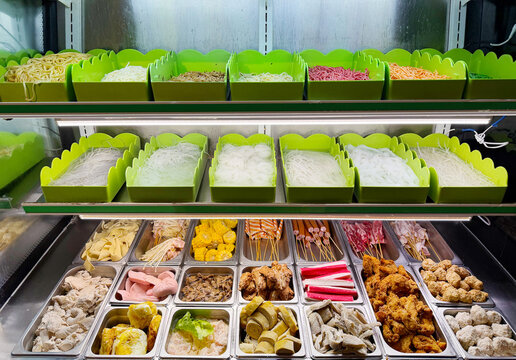 Assorted Wok Ingredients on Display in Asian Restaurant &ndash; Fresh Mushrooms, Greens, Sliced Vegetables, Various Noodles, Glass Noodles, Meatballs, Shrimp and Chicken for Custom Stir-Fry