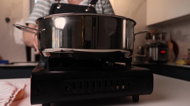 Pot on a portable gas stove cooking in a warm domestic kitchen