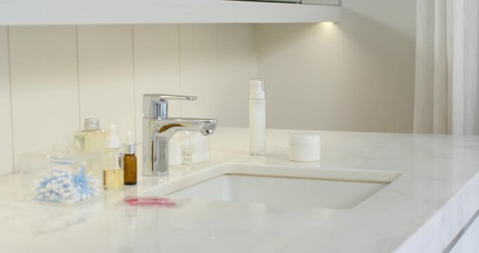 Camera adjusting focus and exposure, sink and chrome faucet holding center, reflections shifting