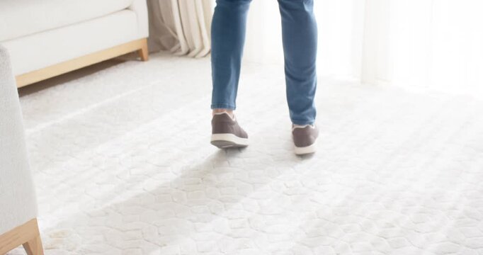 With weight shift initiating motion legs and feet are taking steps across rug while balancing