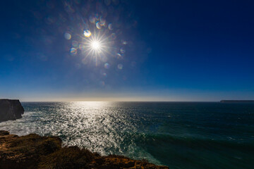 View of a picturesque beach on the Atlantic Ocean, with crashing waves under a blue sky, Sagres Viewpoint, Algarve region, Faro district, Portugal – background or wallpaper  © anettastar