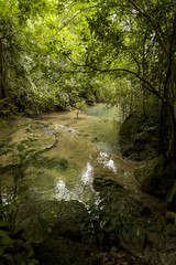 Emerald natural pool and limestone cascades surrounded by lush jungle foliage in Erawan National Park, Kanchanaburi, Thailand © VaZu Photo