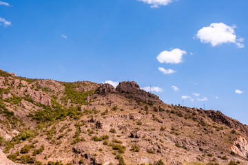 Rocky hill slope under a clear blue sky. This landscape image is perfect for travel, environmental, and geological themed projects. © ismailgazel