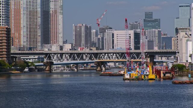 運河にかかる橋とビル群が見える都市の風景。