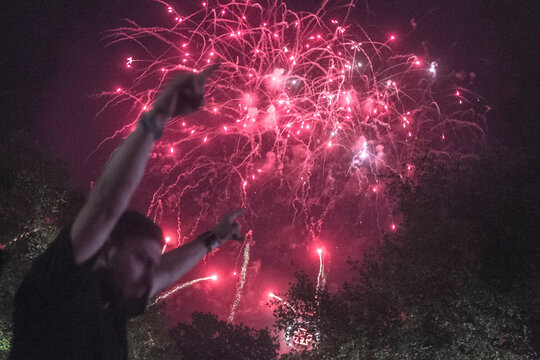 Fan's arm raised under exploding fireworks at a metal music festival in Clisson, France