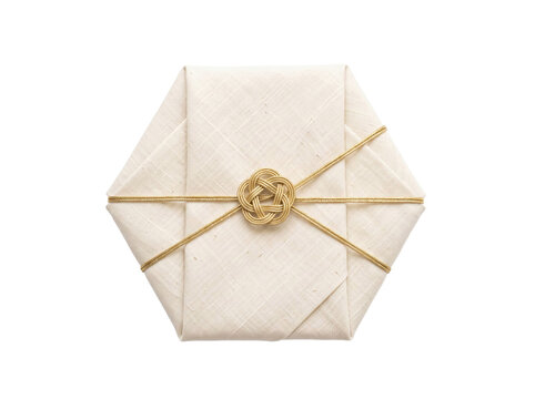 Hexagonal gift box wrapped in cream linen fabric with a decorative gold cord knot on white
