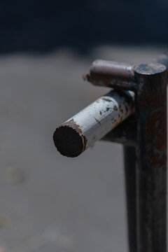 Close-Up Of Rusty Metal Gate Latch Showing Corrosion, Peeling Paint And Weathered Industrial Texture