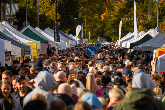 VALMIERA, LATVIA &ndash; OCTOBER 10, 2026: Large Crowd of Shoppers at a Busy Outdoor Autumn Market with Colorful Vendor Tents