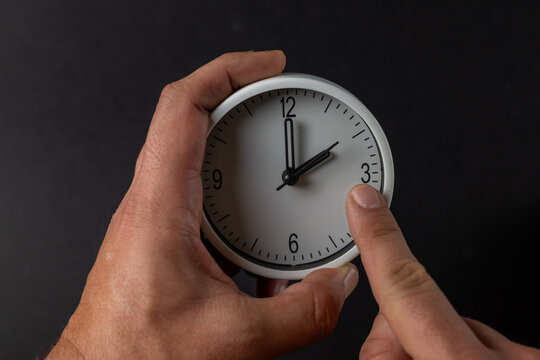 Hands Adjusting an Analog Clock for Time Change