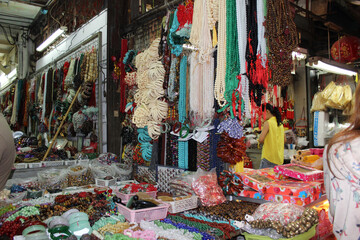 Assorted beaded necklaces and jade bracelets at a traditional market © Intuon