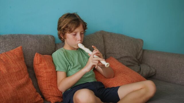 A little boy learns to play the flute at home, practicing with focus and enthusiasm in a cozy, warm setting. A charming scene of early musical exploration, creativity, and childhood growth.