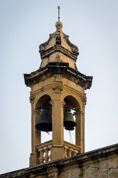 Historic Bell Tower With Two Bronze Bells and Weathered Stone Church Architecture At Dusk