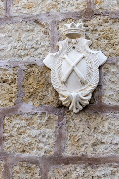White Heraldic Coat of Arms Crest Mounted on Historic Stone Wall With Crown and Laurel Decoration