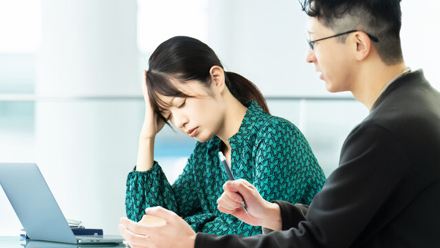 ミーティングをしながら考える男女のビジネスマン