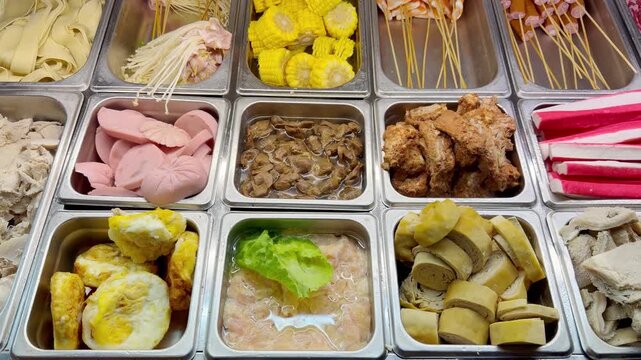 Assorted Wok Ingredients on Display in Asian Restaurant &ndash; Fresh Mushrooms, Greens, Sliced Vegetables, Various Noodles, Glass Noodles, Meatballs, Shrimp and Chicken for Custom Stir-Fry