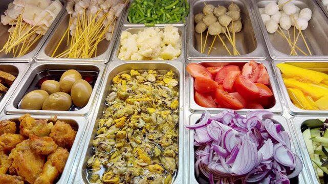Assorted Wok Ingredients on Display in Asian Restaurant &ndash; Fresh Mushrooms, Greens, Sliced Vegetables, Various Noodles, Glass Noodles, Meatballs, Shrimp and Chicken for Custom Stir-Fry