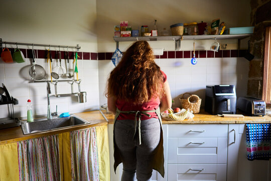 Woman wearing apron cooking in a rustic kitchen
