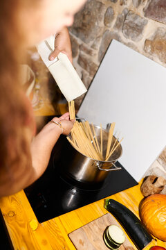 Person cooking spaghetti pasta for a meal