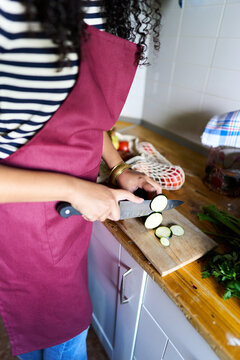 Woman cooking fresh zucchini in home kitchen