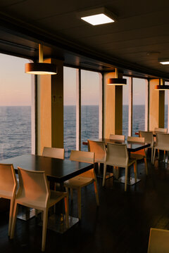 Empty boat living room with large windows bathed in the sunset glow.