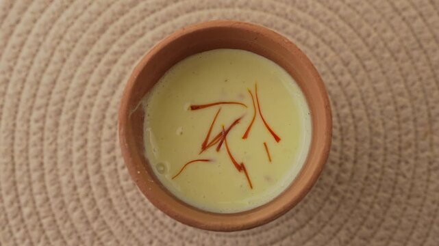Creamy Traditional Indian Lassi Topped with Saffron Strands Served in a Rustic Clay Cup, Close-Up Beverage Shot