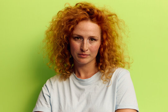 Woman faces the camera in front of a green background