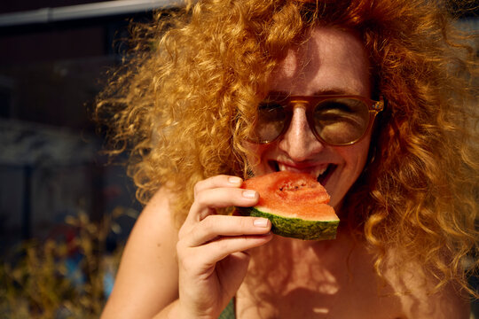 Woman enjoys a piece of watermelon
