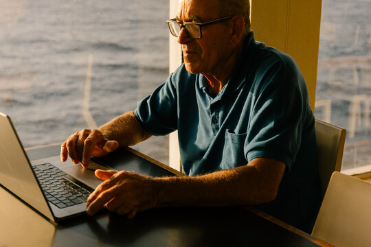 Elderly man working remotely from inside a boat