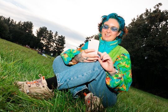 Woman sitting on grass using phone