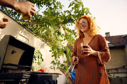 Woman talks to someone while preparing a barbecue