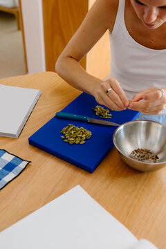 Woman carefully peeling and chopping fresh cardamom