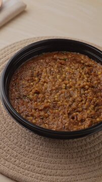 Freshly Cooked Healthy Millet Khichdi Served Hot in a Black Bowl, Close-Up Food Shot.