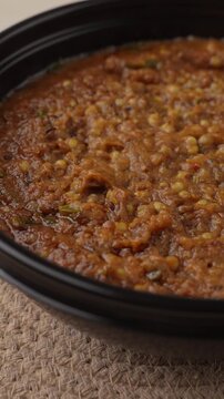 Freshly Cooked Healthy Millet Khichdi Served Hot in a Black Bowl, Close-Up Food Shot.