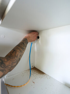 Electrician Connecting LED Lighting to Wooden Cabinet Space