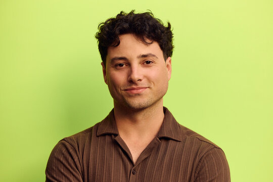 Man smiling in front of a green background