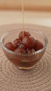Soft Bite-Sized Mini Gulab Jamun Soaked in Warm Sugar Syrup, Traditional Indian Dessert Close-Up Shot