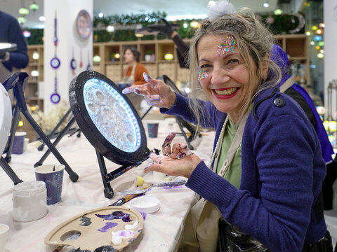 Senior Retiree Smiling While Painting at Crafting Event