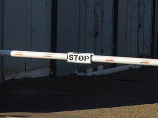 White automatic barrier arm with stop sign mounted in front of building © Rodion