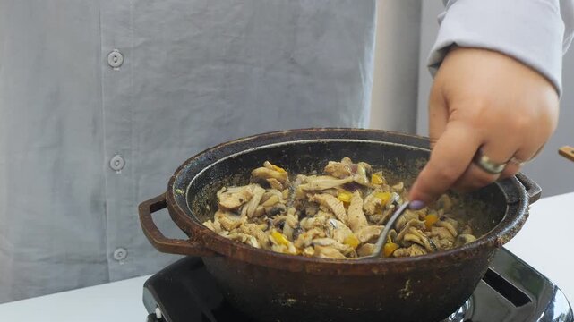 In a deep cast-iron skillet, onions simmer with chicken in a sauce