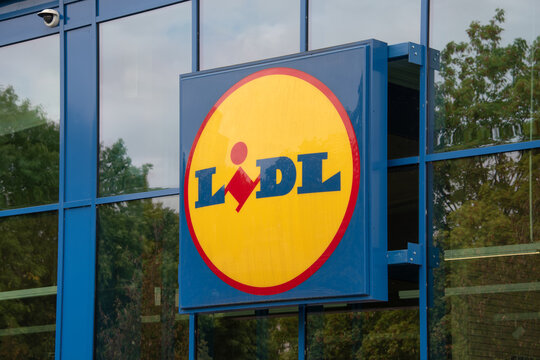 Berlin, Germany - 16 August 2026. A Lidl supermarket sign mounted on a glass storefront outside a retail grocery store. Retail, grocery, discount, brand, shopping, storefront, signage, economy.